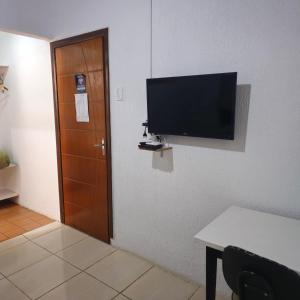 a room with a door and a television on a wall at Kyrie Canoinhas Hotel in Canoinhas