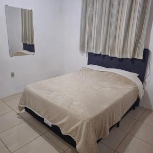 a bedroom with a bed with a blue headboard and a window at Kyrie Canoinhas Hotel in Canoinhas