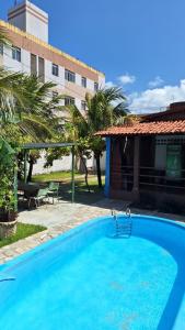 a large blue swimming pool in front of a building at Casa Praiana in Cabedelo
