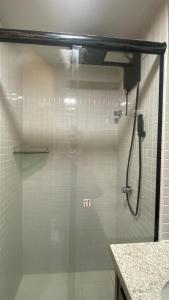 una ducha con puerta de cristal en un baño en NOVO frente ao Mar - 750m da Orla e Pq dos Ventos - Oceanfront - 3 Guests, en Salvador