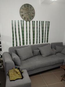 a living room with a couch and a clock on the wall at Appartement F3 aich el vez in Bejaïa +13 photos