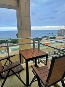 a balcony with a table and chairs and the ocean at Rodamar Apartment Forum Funchal in Funchal