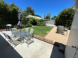 un patio con tavolo, sedie e ombrellone di Baxter Cottage a Bendigo