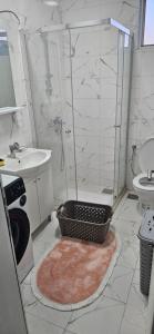 La salle de bains est pourvue d'un lavabo et d'une douche avec un panier. dans l'établissement Jednosoban stan, à Radanovići