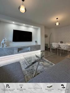 Una sala de estar con un televisor de pantalla plana en una pared. en Le Contemporain, en Troyes