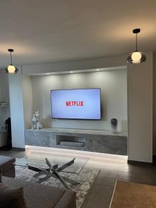 Una sala de estar con un televisor en la pared. en Le Contemporain, en Troyes