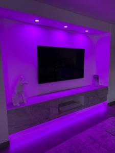 sala de estar con TV con luces moradas en Le Contemporain, en Troyes
