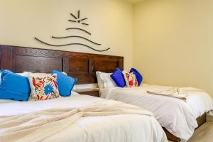 two beds in a room with a sign on the wall at Paz Del Mar 30 in Puerto Peñasco +21 photos