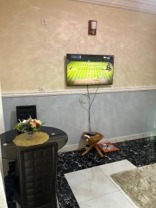 a living room with a flat screen tv on a wall at Appartement Climatisé et Résidence Sécurisée Kribi in Kribi +2 photos