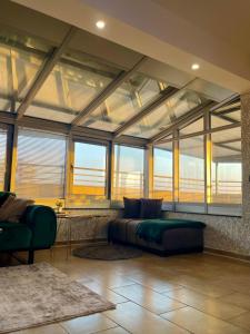 a large living room with a couch and windows at Grisé The Gallery Penthouse in Pristina