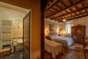 a bedroom with a bed and a bathroom with a tub at Guesthouse da Idolina dal 1946 in Montalcino