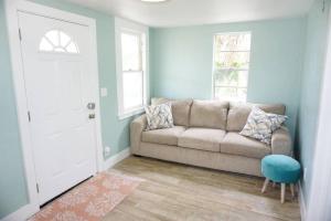 ein Wohnzimmer mit einer Couch und einem Fenster in der Unterkunft Beachside Cottage Walk 2BeachOcean Center PETS OK in Daytona Beach