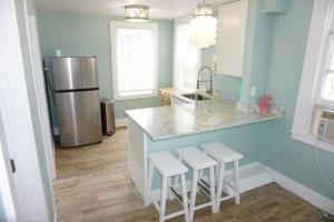 eine Küche mit einer Theke mit Hockern und einem Kühlschrank in der Unterkunft Beachside Cottage Walk 2BeachOcean Center PETS OK in Daytona Beach