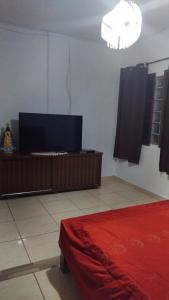 a room with a bed and a flat screen tv at casa da meg in Tiradentes +15 photos