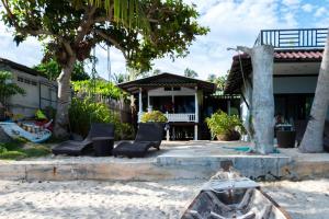 a house on the beach with chairs and trees at Sunset Dream Beach Front House in Thong Sala