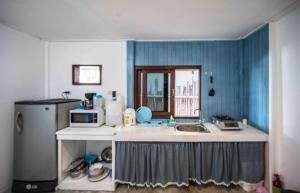 a kitchen with a sink and a microwave at Sunset Dream Beach Front House in Thong Sala