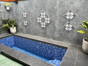 a blue tile tub in a bathroom with plants at Omahe Jogja in Yogyakarta