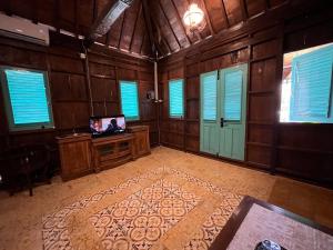 DemanganにあるOmahe Jogjaの木製の壁と窓、そしてラグのあるリビングルーム +8枚の写真