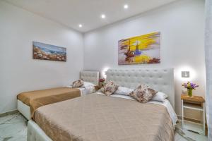 1 dormitorio con 2 camas y 2 cuadros en la pared en Alloggio Turistico Mediterranean Cruises, en Civitavecchia 33 fotos más