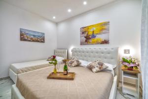 Un dormitorio con dos camas y una mesa con flores. en Alloggio Turistico Mediterranean Cruises, en Civitavecchia