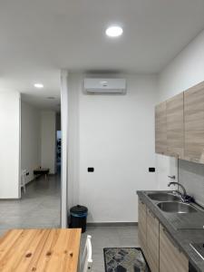 a kitchen with a sink and a wooden table at B&B IN Family in Cotronei