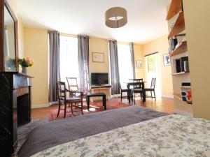 une chambre avec un lit, une table et des chaises dans l'établissement Charmant Appartement Central à Angers - Tout Inclus, Wifi, Proche Gare et Patrimoine - FR-1-622-6, à Angers