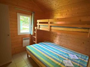 a bedroom with two bunk beds in a log cabin at Chalet Édelweiss 35 en lisière de forêt, calme et nature - FR-1-583-444 in Mélisey