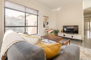 Una sala de estar con un sofá y un televisor. en Golden Retreat - Couples Getaway Business stay, en Golden Square