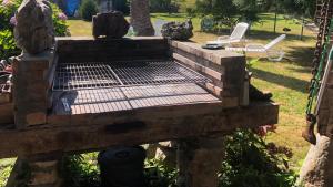 a wooden deck with a grill in a yard at La casa de Cudón in Cudón