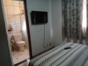a bathroom with a toilet and a television on the wall at Casa Festa do Peão Barretos in Barretos +7 photos