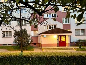 een gebouw met een rode deur ervoor bij Apartament Kochanowskiego Łódź in Łódź