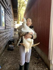 Una mujer sosteniendo un pato frente a un edificio. en Mays Luxury Farmstay, en Los Gatos