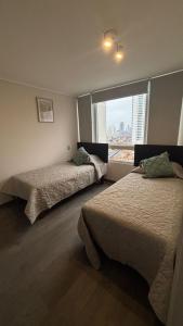 イキケにあるDepartamento nuevo con hermosa vista a playa bravaの窓のある部屋にベッドが2つある