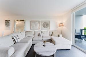 a living room with a white couch and a table at Prime Beach and Golf Retreat 2BR Pool & Balcony in Boca Raton