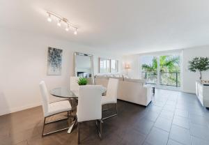 a dining room and living room with a table and chairs at Prime Beach and Golf Retreat 2BR Pool & Balcony in Boca Raton +42 photos