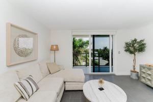 a living room with a white couch and a table at Prime Beach and Golf Retreat 2BR Pool & Balcony in Boca Raton
