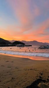 - une plage au coucher du soleil avec une jetée dans l'eau dans l'établissement Casa mar, à Angra dos Reis