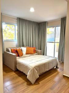 une chambre avec un grand lit avec des oreillers dessus dans l'établissement Pousada Sol da Mantiqueira - Inauguração, à Campos do Jordão