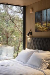 a bedroom with a bed with a large window at Lakeside ÖÖD Mirror Cabin #2- Austin Nature Stay in Bastrop