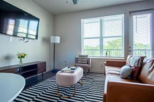 a living room with a couch and a tv at Boulevard Stays Comfortable 1BR Suite w Pool Parking Gym 04 in Dallas