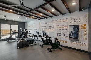a gym with cardio machines and a wall with posters at Boulevard Stays Comfortable 1BR Suite w Pool Parking Gym 04 in Dallas