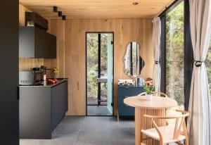 a kitchen and dining area with a table and chairs at Lakeside ÖÖD Mirror Cabin #1 - Nature Getaway in Bastrop