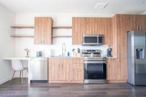 达拉斯Boulevard Stays Comfortable 1BR Suite w Pool Parking Gym 05的厨房配有木制橱柜和不锈钢冰箱