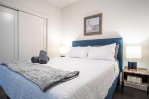 达拉斯Boulevard Stays Comfortable 1BR Suite w Pool Parking Gym 05的一间卧室配有蓝色和白色的床以及两盏灯。