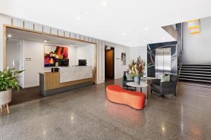 a living room with an orange chair and a table at Quarters at Flinders Hotel in Flinders