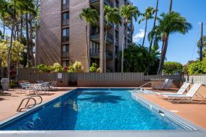 カハナにあるNEW-Maui is Calling - Ocean View Modern Chic West Maui Retreatのヤシの木が茂る建物の前にあるスイミングプール