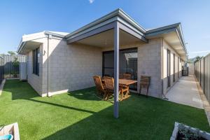 a patio with a table and chairs on a lawn at Treeby's Finest Family Home 4bdr 2bth in Perth