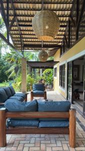 un patio avec un grand canapé bleu sur un patio dans l'établissement Holiday Villa Praia da Pipa-5 Suites,Areá Gourmet by PipaCharme, à Pipa