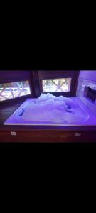 a large bed in a room with two windows at Sítio Vista Alegre in São Luiz do Paraitinga