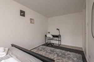 a white bedroom with a bed and a desk at Luxus Flat Near Leeds City Centre in Central Station